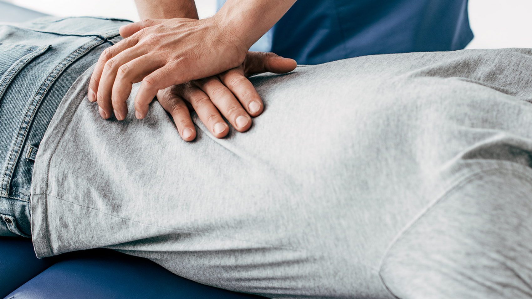 chiropractor massaging back of man on Massage Table in hospital